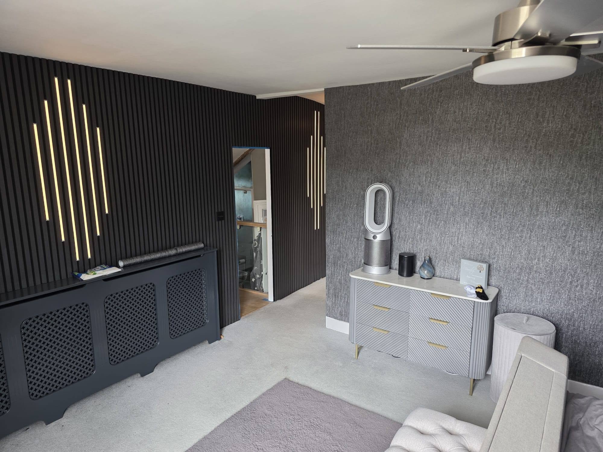 Dark textured panelled feature wall with vertical LED lighting installed by Essex Decorating Solutions